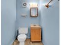 Cozy blue bathroom featuring a standard toilet, a wooden vanity, and an overhead light at 5301 Old Smith Valley Rd, Greenwood, IN 46143