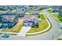 An aerial view showcases a home with a well-manicured lawn and a large driveway within a vibrant community at 5839 Altar Bell Cir, Greenwood, IN 46143