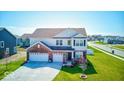 Inviting two-story home with a well-manicured lawn and three-car garage at 5839 Altar Bell Cir, Greenwood, IN 46143