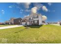 Charming home featuring a three-car garage, manicured lawn, and mature landscaping at 5839 Altar Bell Cir, Greenwood, IN 46143