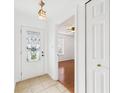 Bright entryway with a decorative glass door, neutral tile flooring, and an open view to living area at 6233 Boulder Dr, Anderson, IN 46013