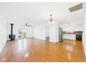 Open-concept living area with hardwood floors, fireplace, and stainless steel appliances in adjacent kitchen at 6233 Boulder Dr, Anderson, IN 46013
