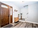 Bright foyer with wood-look floors, a modern wooden cabinet, and staircase at 632 Ridgeview Ln, Columbus, IN 47201