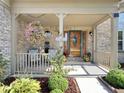 Charming front porch with brick facade, decorative flowers, and a welcoming atmosphere at 7034 Endicott Way, Indianapolis, IN 46259