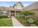 Inviting entryway showcasing a well-maintained lawn, mature landscaping and beautiful brick exterior at 732 Trillium St, Lebanon, IN 46052