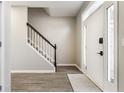 Bright entryway featuring hardwood floors, a staircase with white railings, and a front door with glass panels at 8415 Anchorage Ct, Indianapolis, IN 46236