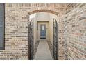Arched brick entryway featuring a decorative metal gate and inviting front door at 8433 Quail Hollow Rd, Indianapolis, IN 46260