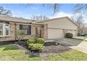 Charming brick home with a well-maintained lawn, mature tree, and attached two-car garage at 8433 Quail Hollow Rd, Indianapolis, IN 46260