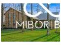 Attractive home featuring a brick exterior, well-manicured lawn, and mature trees enhancing its appeal at 8500 N Ravenwood Dr, Muncie, IN 47303