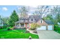Two-story brick home featuring an attached garage, a covered porch, and a well-maintained front yard at 8695 Shoe Overlook Dr, Fishers, IN 46038