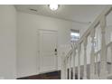 Bright entryway featuring modern lighting and a white staircase with carpeted stairs at 8961 Fitzgerald Dr, Indianapolis, IN 46239
