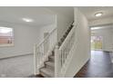 View of the staircase showing the transition from wood to carpet and an open concept floor plan at 8961 Fitzgerald Dr, Indianapolis, IN 46239