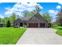 Charming brick home with a three-car garage and lovely landscaping at 9879 Ruby Ct, Mooresville, IN 46158