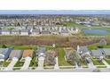 Aerial view of a single-Gathering home in a suburban neighborhood with pond in the distance at 10876 Bellflower Ct, Indianapolis, IN 46235