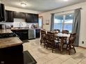 Well-lit kitchen with stainless steel appliances, dark cabinets, and a view of the backyard at 122 Southlane Dr, New Whiteland, IN 46184