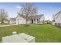 View of the front of the home, showing vinyl siding, and a two-car garage, with landscaping at 12223 Split Granite Dr, Fishers, IN 46037