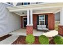 Inviting front porch featuring a cozy seating area, brick pillars, and well-maintained landscaping at 1291 Timber Bluff Rd, Westfield, IN 46074
