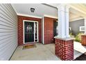 Welcoming front porch with a black door, decorative wreath, and a charming welcome mat at 1291 Timber Bluff Rd, Westfield, IN 46074