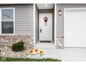 Close-up of the home's inviting front door with wreath and attractive exterior lighting at 1631 W Paula Dr, Columbus, IN 47201