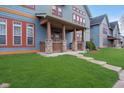 View of a welcoming front porch featuring stone pillars and a well-manicured lawn at 1635 N College Ave # 5, Indianapolis, IN 46202