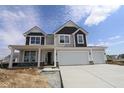 New two-story home showcasing a two-car garage, neutral siding, and a charming front porch at 17026 Cowbell Dr, Noblesville, IN 46060