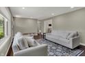 Bright living room featuring hardwood floors, neutral walls, white sofas, and decorative area rug at 1750 W Stop 11 Rd, Indianapolis, IN 46217