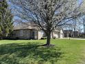 Lush green backyard featuring mature trees with a patio area, perfect for outdoor living at 18346 Piers End Dr, Noblesville, IN 46062