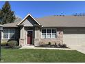Charming brick home featuring an attached garage, green lawn and updated windows at 18346 Piers End Dr, Noblesville, IN 46062