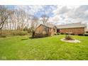 Expansive backyard with lush green lawn, landscaping, and the rear of the brick house at 206 Somerville Rd, Anderson, IN 46011