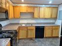 Functional kitchen features light wood cabinets, a black dishwasher, and black electric stove at 2260 N Graham Ave, Indianapolis, IN 46218
