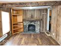 Living room features hardwood floors, a stone fireplace, a wood bookshelf, and wood paneled walls at 2260 N Graham Ave, Indianapolis, IN 46218