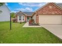Inviting home with a well-kept lawn, red rose bushes, and an attached two-car garage at 2390 Lakecrest Dr, Columbus, IN 47201