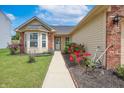 Home with landscaped front yard, brick details, charming bay window, and a paved walkway at 2390 Lakecrest Dr, Columbus, IN 47201