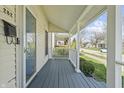 View of the home's charming covered front porch with painted wood floors and white columns at 282 N Vine St, Plainfield, IN 46168