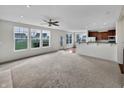 Open-concept living space with neutral tones, large windows and view into adjacent kitchen area at 2859 Dursillas Dr, Plainfield, IN 46168