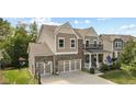 Beautiful two-story home with a three-car garage, brick accents, covered porch, and backyard basketball hoop at 4285 Nottinghill Dr, Avon, IN 46123