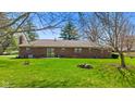 Expansive backyard with lush green grass, mature trees, and ample space for outdoor activities at 5132 W Blue Bell Dr, New Palestine, IN 46163