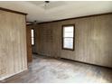 Spacious living room featuring paneling, hardwood floors and three windows offering plenty of natural light at 5810 Greenfield Ave, Indianapolis, IN 46219