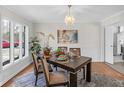 Inviting dining room features a modern chandelier and a large window for natural light at 5917 Camelback Ct, Indianapolis, IN 46250
