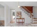 Elegant foyer with marble flooring, a decorative table, and a staircase with wooden accents at 5917 Camelback Ct, Indianapolis, IN 46250
