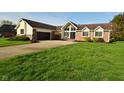 Attractive home featuring a brick facade, well-maintained lawn, and a spacious driveway with curb appeal at 6276 Quail Rdg W Dr, Plainfield, IN 46168