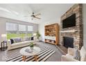 Bright living room with fireplace, ceiling fan, and large windows overlooking the front yard at 6681 Keepsake Dr, Whitestown, IN 46075