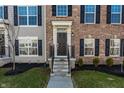 Inviting front entry with a black door, white trim, and a well-kept lawn with shrubbery at 6953 Equality Blvd, Carmel, IN 46033