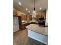 Well-equipped kitchen showcasing granite countertops, wood cabinets, stainless steel appliances, and modern pendant lighting at 798 James William Ln, Westfield, IN 46074