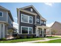 A beautiful view of a two-story home with a covered porch, green grass, and landscaping at 799 Rose Garden Way, Westfield, IN 46074