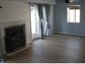 Cozy living room with fireplace, plank flooring, and access to outdoor patio at 8158 Shorewalk Dr # F, Indianapolis, IN 46236