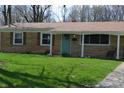Close up of a brick home with a light teal front door and well-maintained lawn at 838 Highland Dr, Whiteland, IN 46184