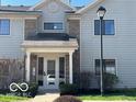 Charming two-story condo features a welcoming front porch and manicured landscaping at 963 Wickham Ct # 103, Carmel, IN 46032