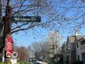 A street corner with Wickham Ct sign and mature trees shading condo complex at 963 Wickham Ct # 103, Carmel, IN 46032