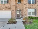Inviting front entrance with a brown door, green bushes, and lush green lawn at 1075 Barberry Dr, Greenwood, IN 46143